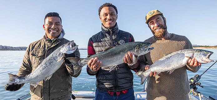 three men holding salmon they caught on a charter fishing outing