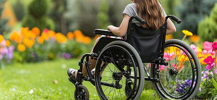 girl in wheelchair looking at flowering garden